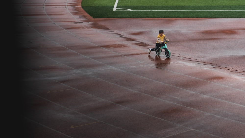 Paint By Numbers | Changsha - Boy In Blue Shirt Riding Bicycle On Track Field During Daytime - Custom Paint By Numbers