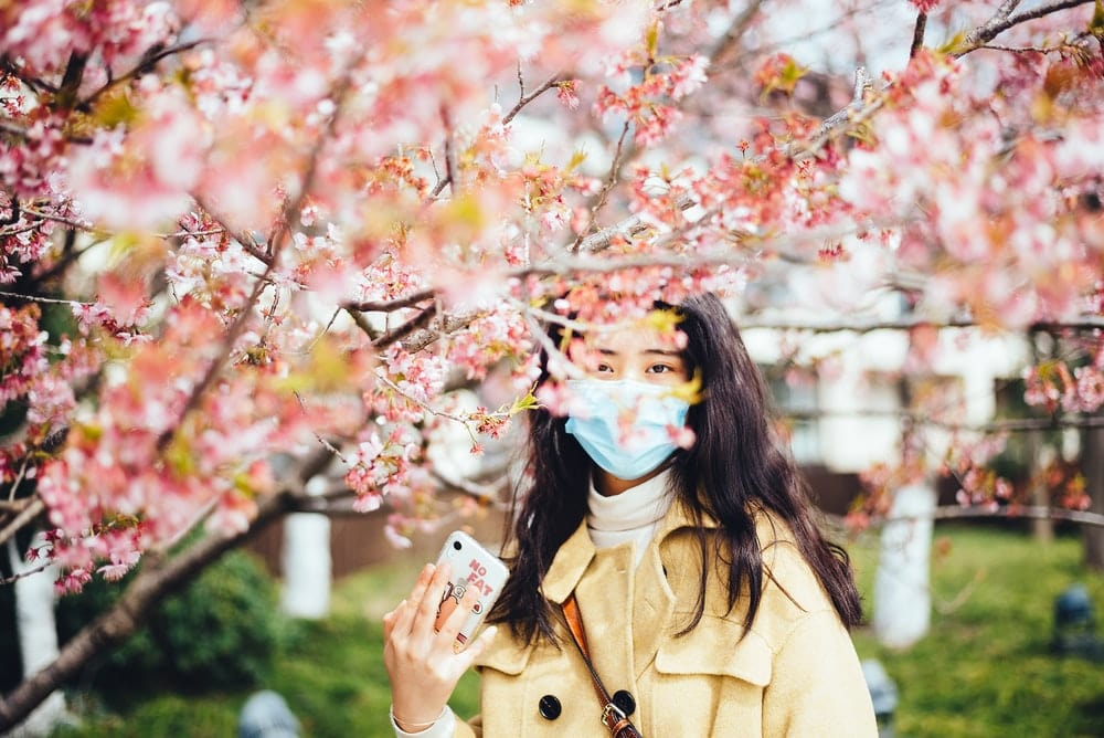 Paint By Numbers | Yangzhou - Woman In Brown Coat With Blue And White Face Mask Holding White Smartphone - Custom Paint By Numbers